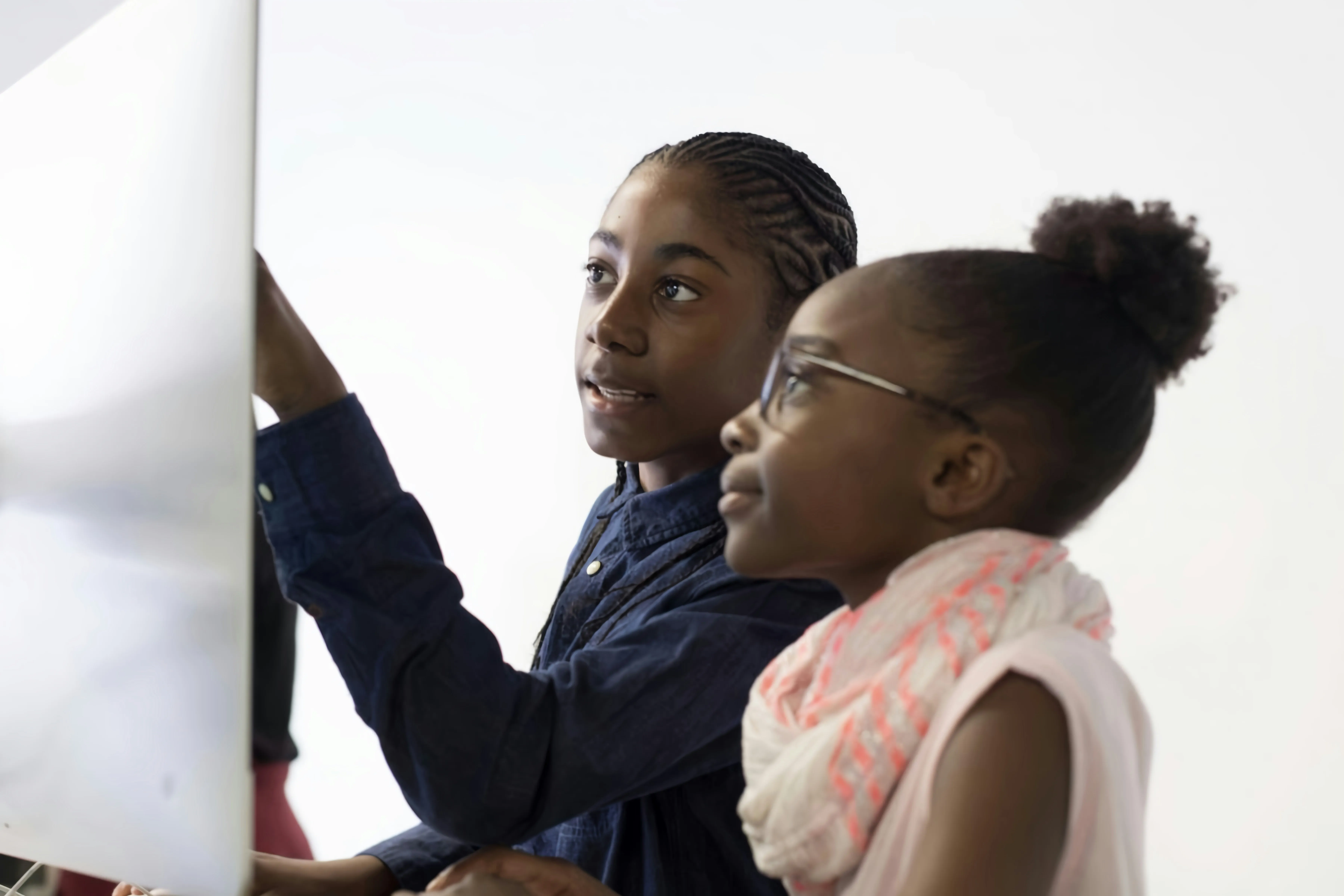 two children observing a screen