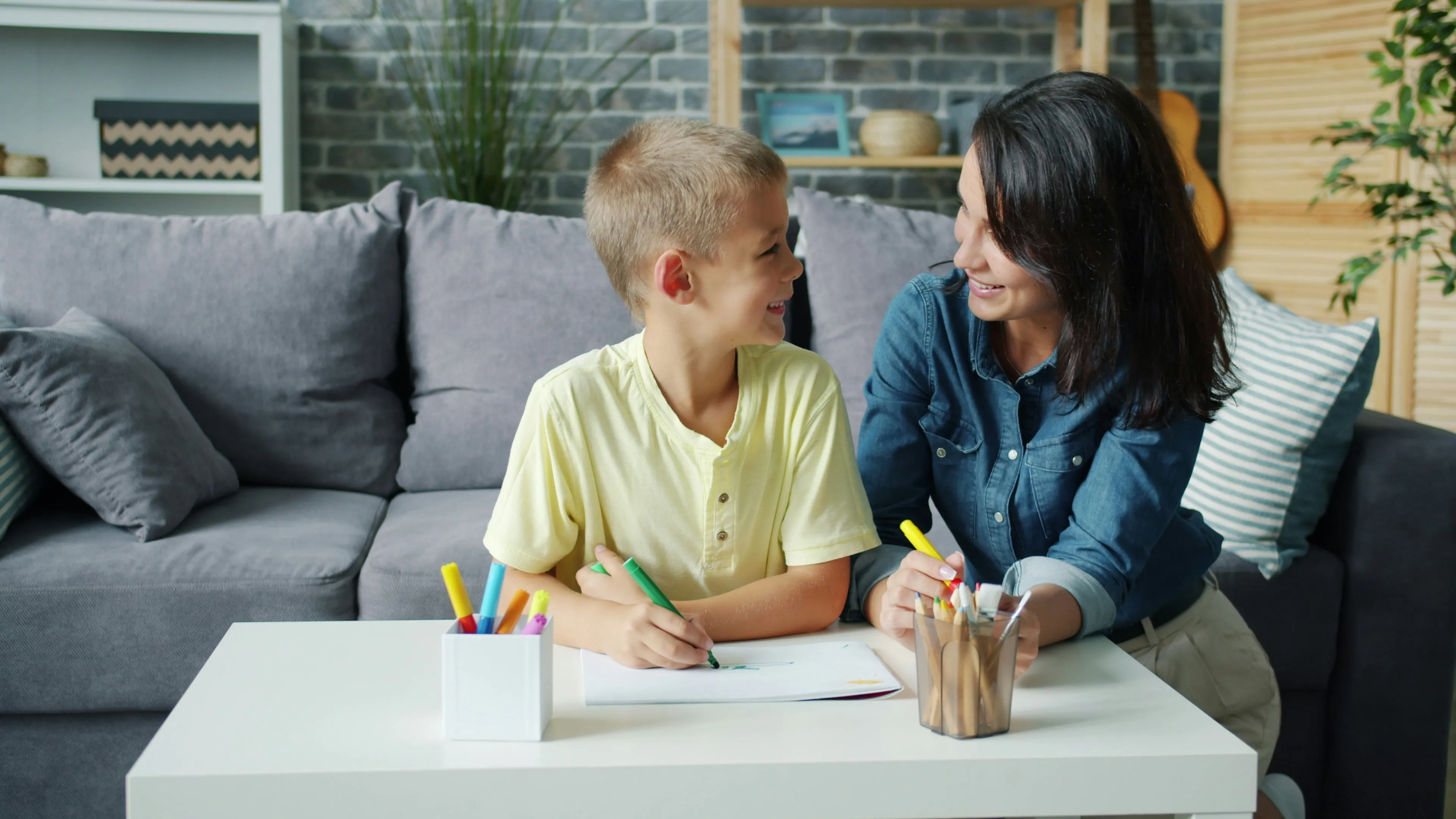 mother drawing with child in a living room