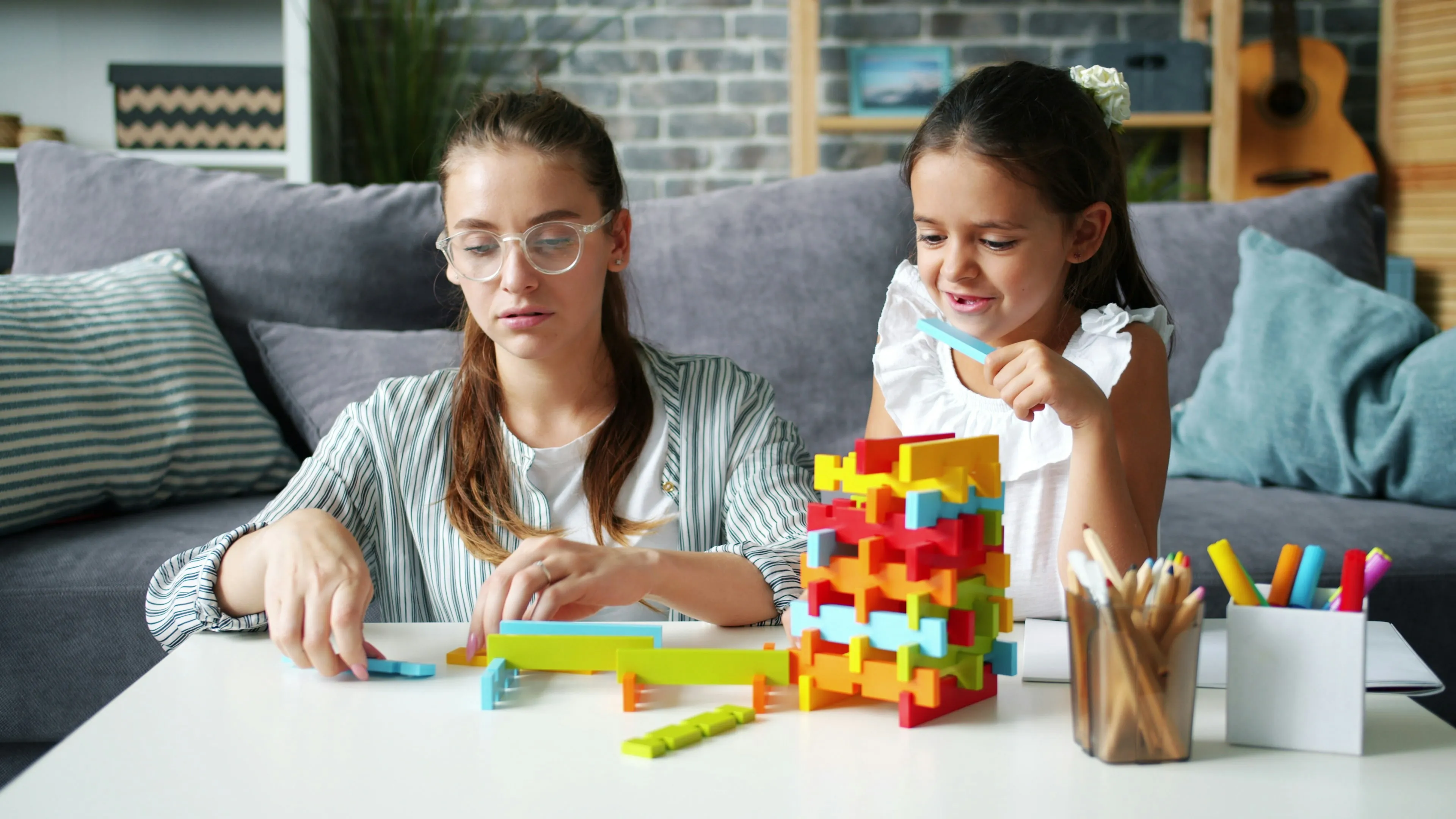 mother and daughter playing with blocks on table